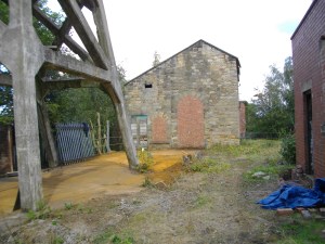 A large area under the headgear and up to the winding house has been cleared of thick surface vegetation and rubble.