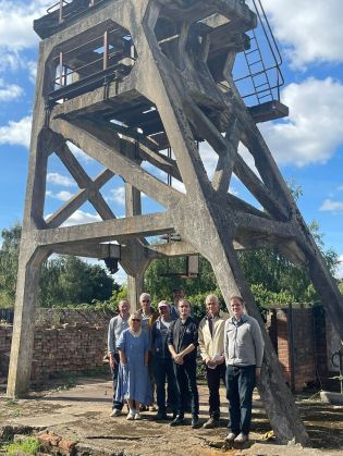Chair of the Friends of Hemingfield Colliery with regular volunteers under the main headgear, Sept 2022